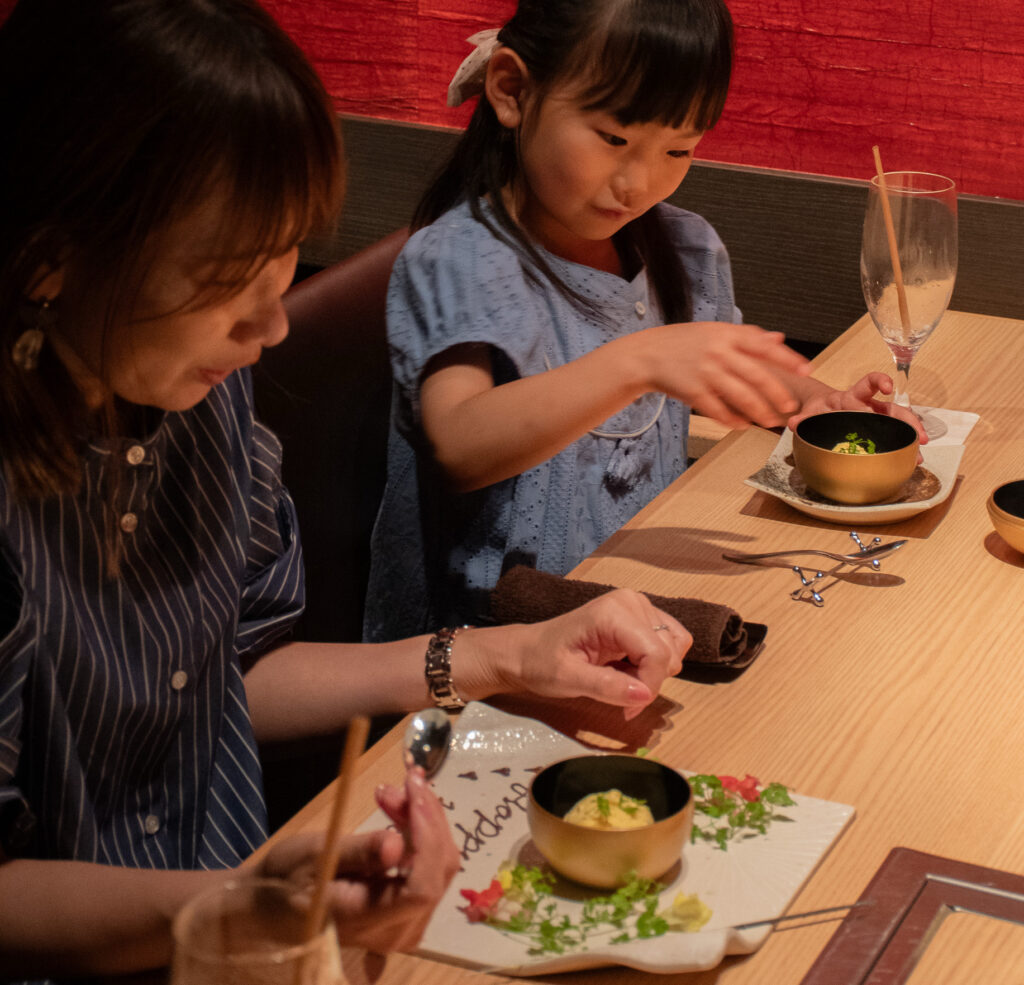 家族で来店した奥様がバースデープレートのデザートを召し上がっている