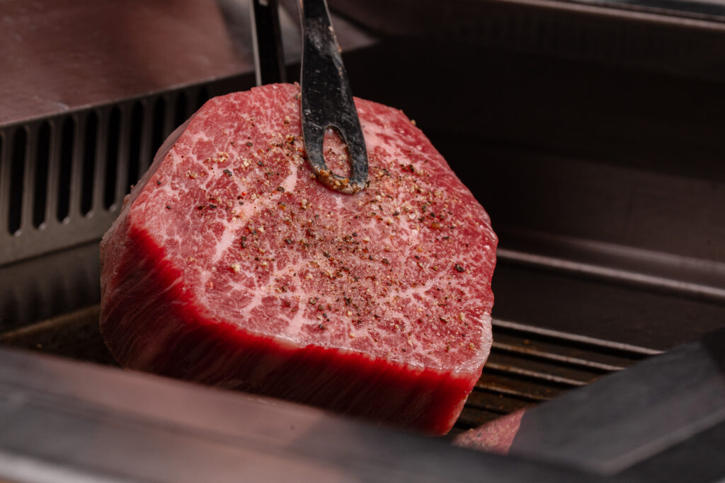 うしうららの料理人が和牛に火を入れる場面